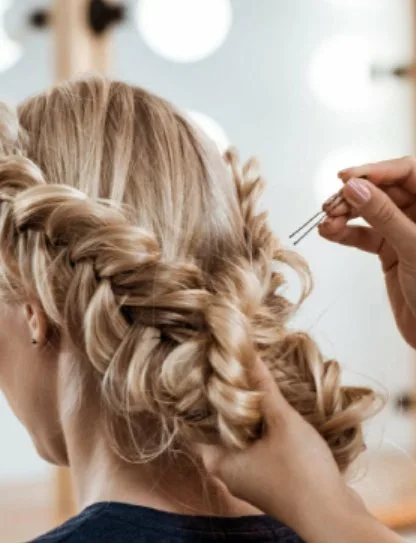 mujer rubia de espaldas recibiendo peinándose con zoom